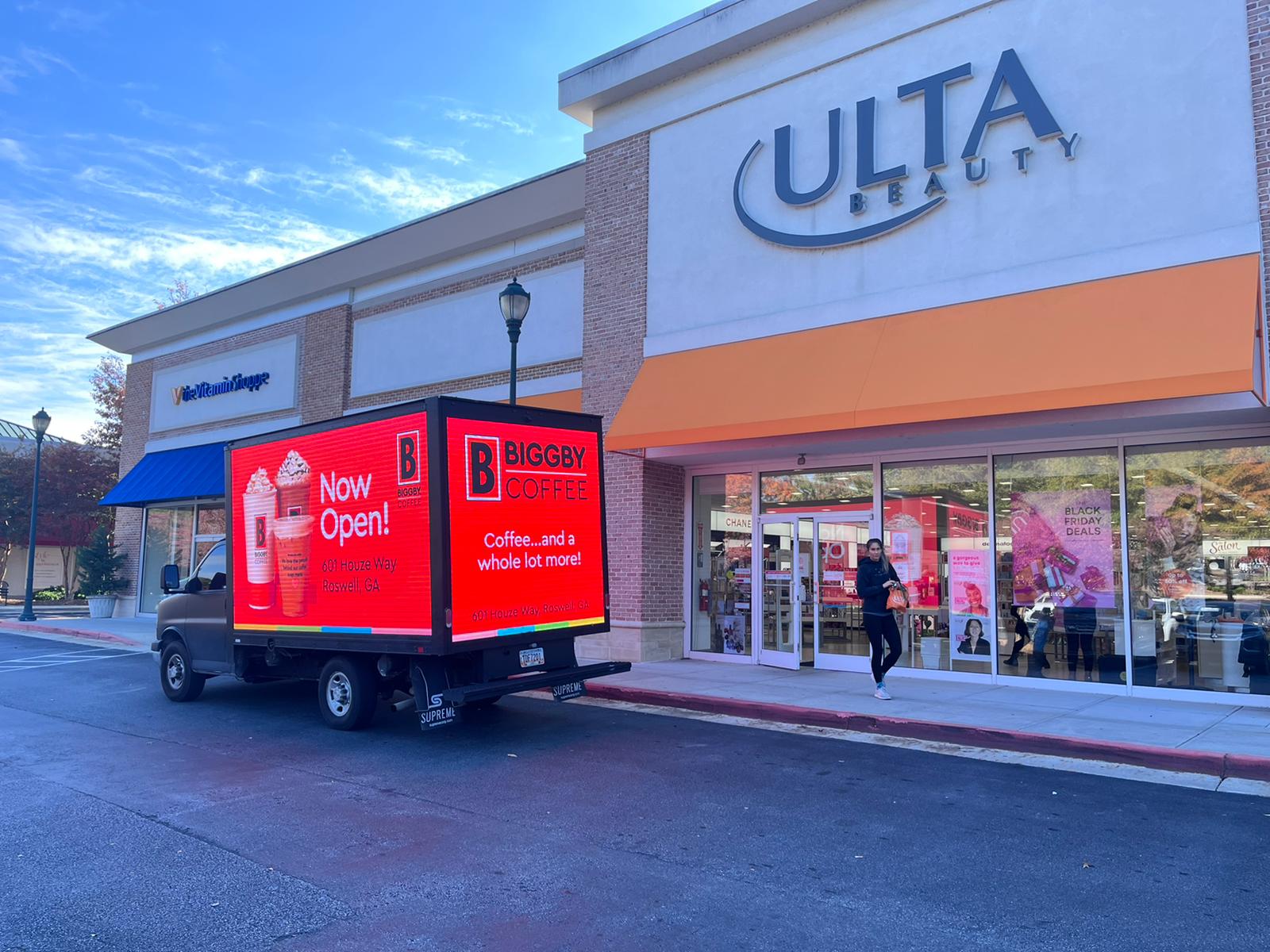 Cantmiss.US LED mobile billboard truck parked outside Ultra Beauty, displaying an advertisement for Biggby Coffee located at 601 Houze Way, Roswell, GA. The billboard is strategically positioned to target a demographic interested in both beauty and specialty coffee.