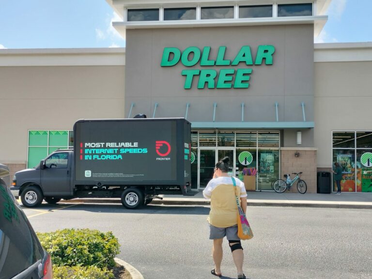 Dollar Tree storefront with Cantmiss.US digital billboard truck showcasing Frontier's 'most reliable internet speeds in Florida.' Nearby shopper illustrates high foot traffic.