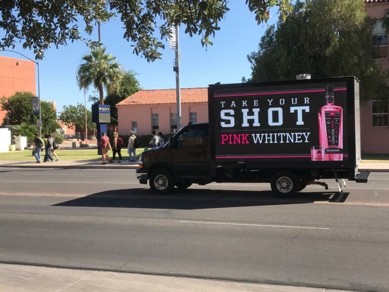Cantmiss.US mobile billboard truck displays an advertisement for 'Pink Whitney' with the tagline 'Take Your Shot' and an image of a pink liquor bottle.