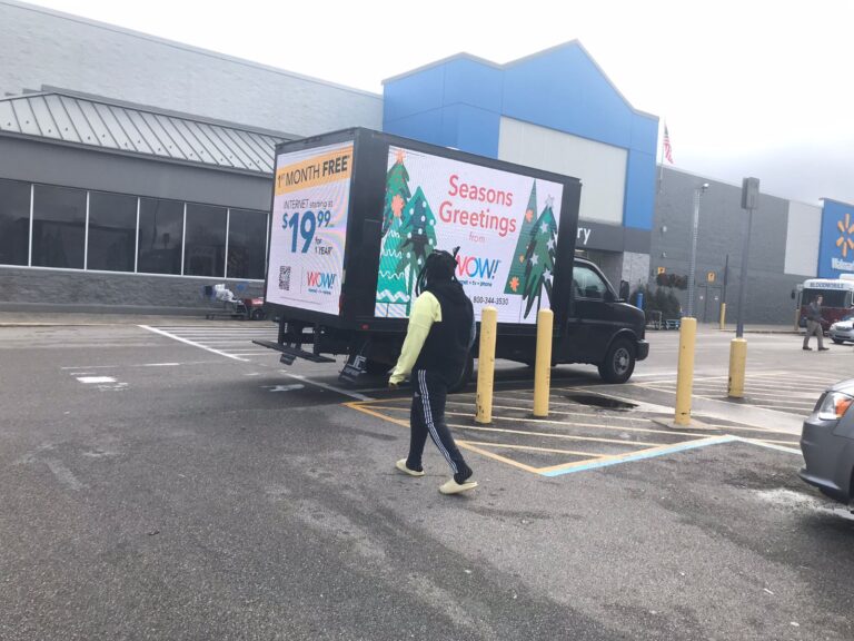 A Cantmiss.US digital mobile billboard truck parked outside a Walmart store, advertising storage solutions and extending holiday greetings.