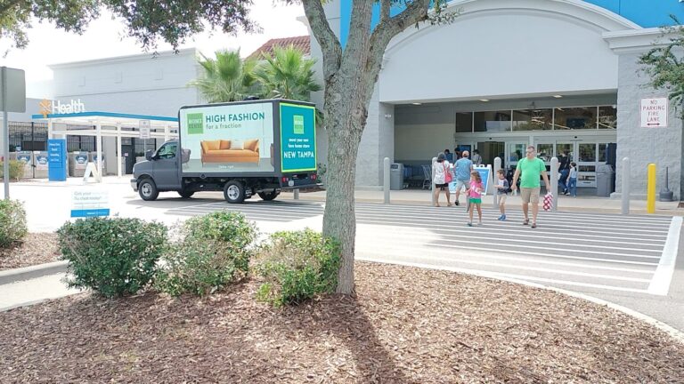 Mobile billboard advertising truck displaying “High Fashion for a fraction”. LED truck parked near busy footfall New Tampa Walmart.