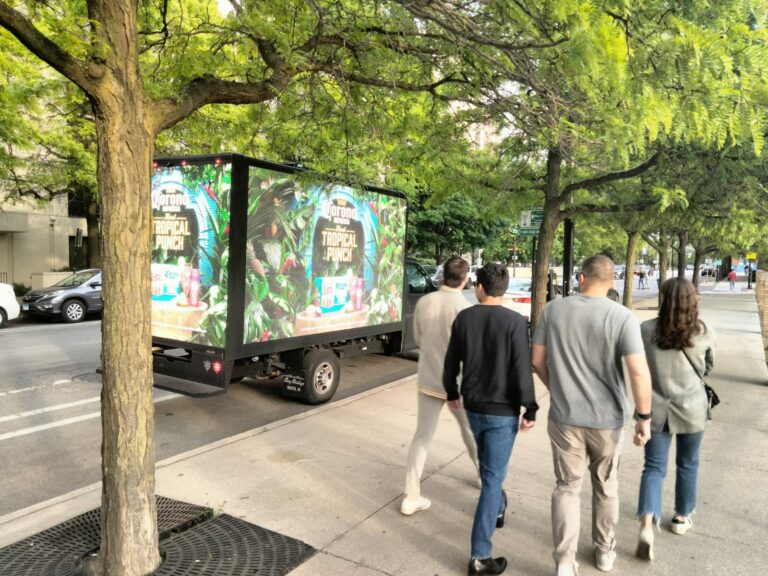 Pedestrians walking by a Can't Miss US' mobile billboards advertising Captain Morgan Tropical Punch in a forestry graphic setting.