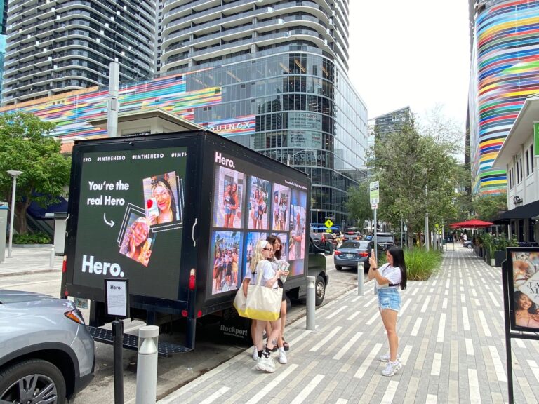The Image Highlights Mobile Billboards Are Better Option to Traditional Billboard featuring 'Hero' campaign on an urban Miami street.