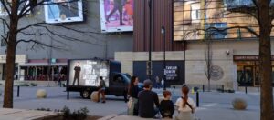 Advertisement truck with Chris Young ad parked beside a side walk with a crowd in front of Country Music Hall of Fame in Nashville.