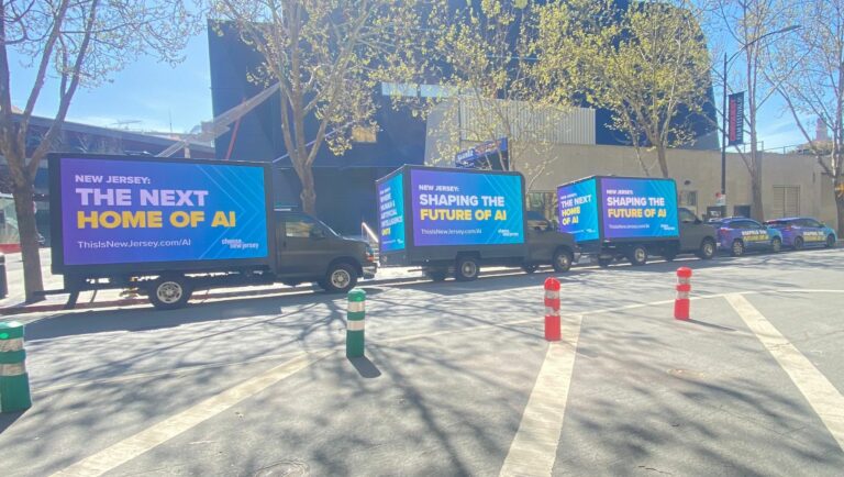 a Fleet of Mobile Billboard Advertisement LED Trucks with ThisIsNewJersey AI slogans parked beside a sunny sidewalk - Mobile Billboard LED Trucks