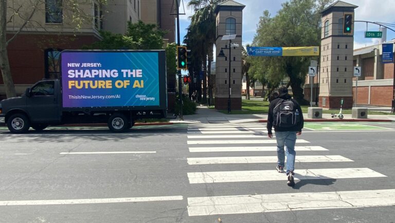 Mobile Billboard advertisement LED truck with ThisIsNewJersey AI future message parked on a sidewalk near a pedestrian on 10th street in New Jersey