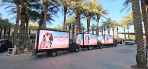 Fleet of Billboard Trucks parked for Coachella with PrettyLittleThing branding. Beautiful Palm Tries behind LED truck