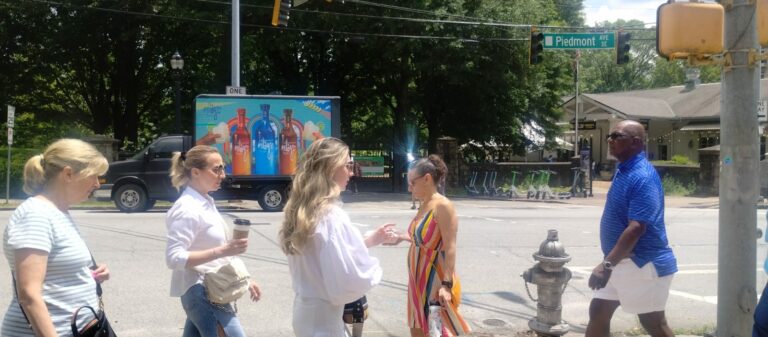 People walking near Piedmont Avenue in Atlanta with a Digital Mobile Billboard advertising truck for Milagro Tequila on a Sunny weather.