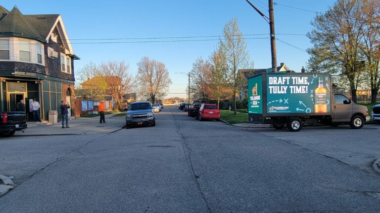 Mobile Billboard Truck for Tullamore Dew advertisement with a slogan of "Draft time, Tully time!" parked on a serene street at dusk in Detroit