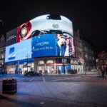 Large digital billboard at Piccadilly Circus in London displaying a variety of ads for Samsung, Lancôme, Armani Exchange and etc.
