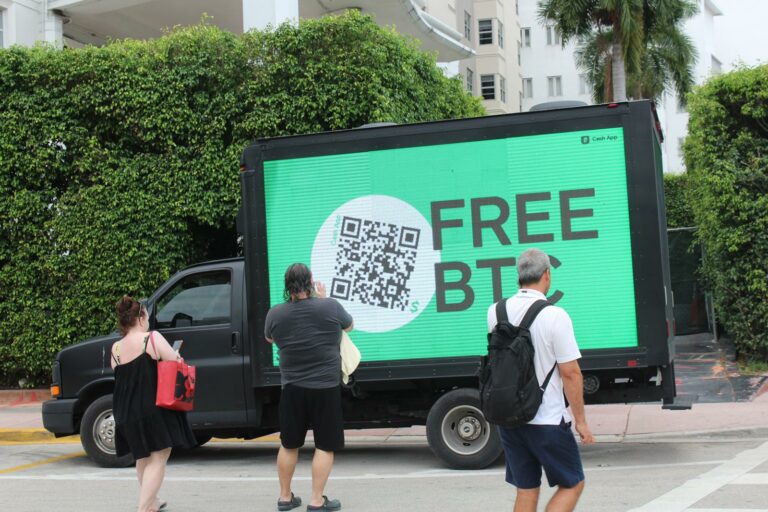 Outdoor advertising truck for Cash App with the free BTC ad and QR code in Miami promotion. Several people are seen to scanning the code.